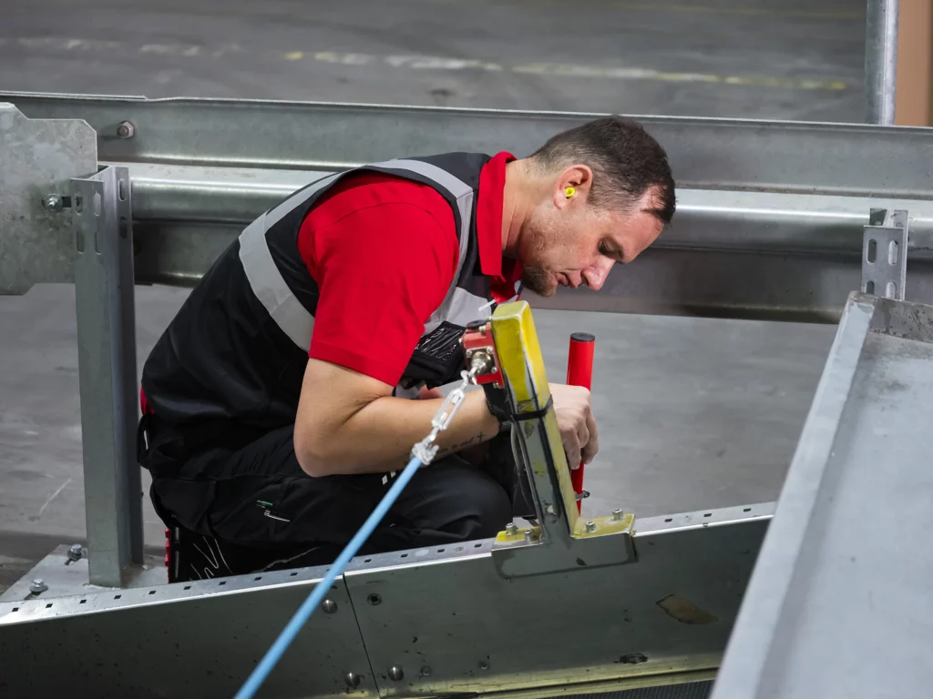 Mann installiert U-TECH FLEX-Komponente in Fabrikhalle.